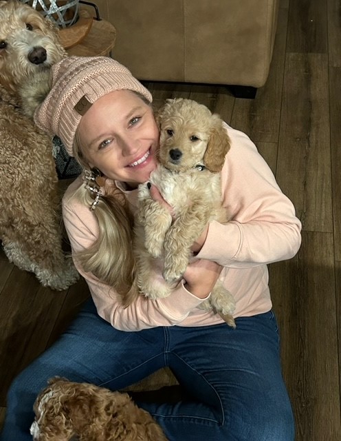 Angie Smith posing for a photo with a puppy
